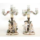 Pair of Continental porcelain Sitzendorf candelabra modelled as children by a tree stump, the