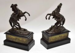 Pair of spelter models of Marley horses raised on black slate plinths with a pressed brass banding