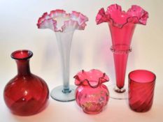 Group of cranberry wares including two large trumpet shaped vases, a further vase and a globular