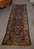 Caucasian type floor runner with geometric designs with a multi-gull border, in reds, blue and