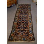 Caucasian type floor runner with geometric designs with a multi-gull border, in reds, blue and