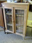 MID-20TH CENTURY OAK FRAMED BOOKCASE WITH TWO LEADED AND GLAZED DOORS RAISED ON PAD FEET