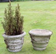 Pair of weathered cement or composition garden urns of circular form moulded with swag decoration,