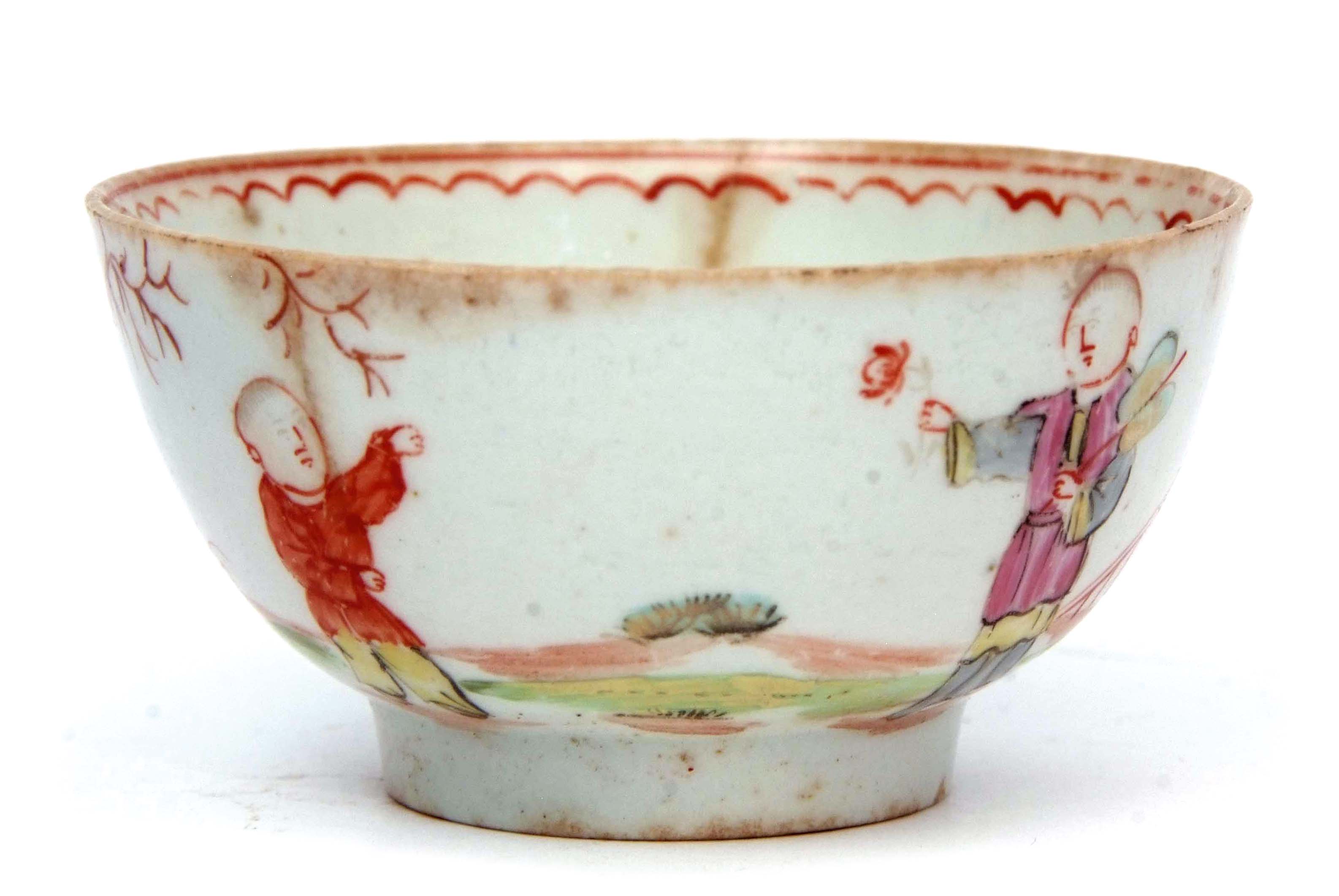 Early Lowestoft polychrome tea bowl with Chinese figures by a fence, the interior with line and loop