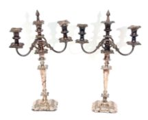 Two early 20th century silver on copper three-light candelabra, each with square section nozzles and