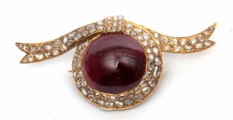 Garnet and diamond brooch, the cabochon oval shaped garnet set within a diamond set ribbon surround,