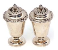 Two Indian colonial silver casters, each with pierced pull off covers and cast and applied finials