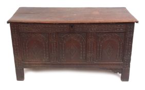 Late 17th/early 18th century oak coffer, plain plank top over a three-panelled front carved with
