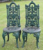 Pair of green painted Coalbrookdale style cast iron garden chairs, the backs each moulded with busts