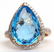 Modern blue topaz and diamond cluster ring, set with a pear cut blue topaz, 11.49ct (est), within