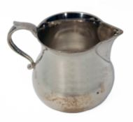 Elizabeth II water jug of polished circular baluster form with applied spout and cast C-scroll