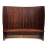 19th Century oak Tavern settle, curved form with boarded back above a solid seat flanked by panel