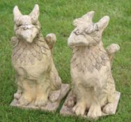 Pair of weathered cement or composition griffins, each in seated poses, 50cm high