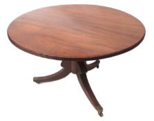 Regency period mahogany circular dining table, with reeded edge, raised on lobed baluster support