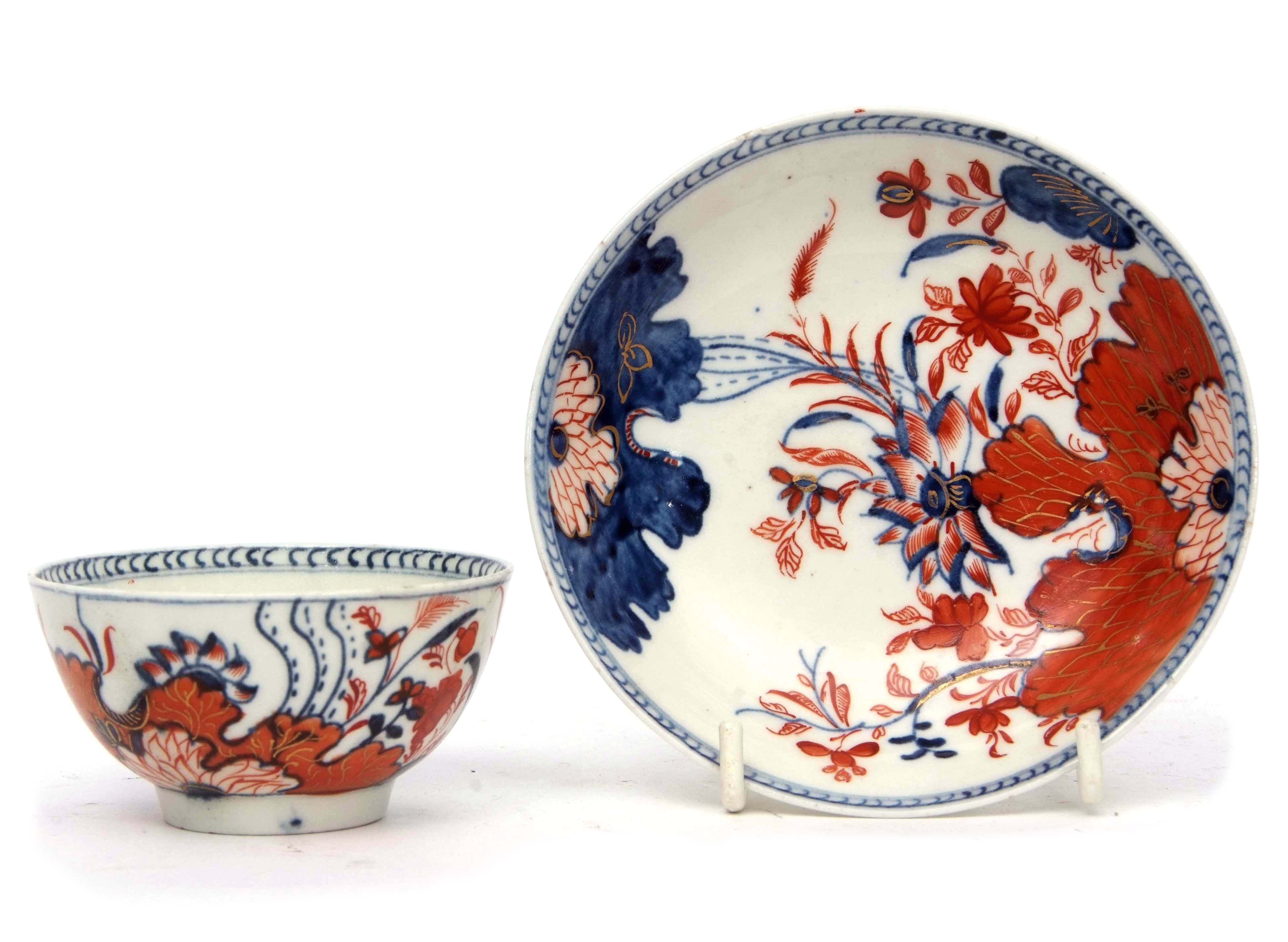 Unusual Lowestoft porcelain tea bowl and saucer with an Imari type tobacco leaf design in iron red