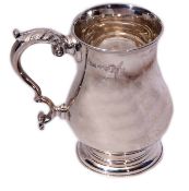 George V baluster tankard of polished form with reeded rim and leaf capped C-scroll handle on a