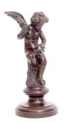 Bronze study of seated winged cupid clutching a broken arrow on a spreading circular base,