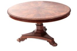 Regency period mahogany circular pedestal dining table with beaded rim raised on a hexagonal support