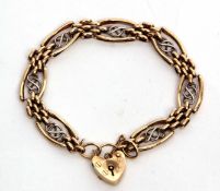 Two-tone 9ct gold pierced panelled bracelet, featuring a heart padlock and safety chain fitting,