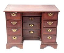 Early 18th century padauk desk, repaired top over central well, fitted with four drawers flanked on