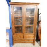 GOOD QUALITY BEECHWOOD FRAMED BOOKCASE WITH TWO DOORS WITH GLASS SHELVES OVER TWO DRAWERS WITH