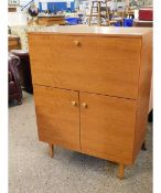 TEAK EFFECT RETRO DRINKS CABINET WITH DROP FRONT OVER TWO CUPBOARD DOORS WITH CIRCULAR BAKELITE