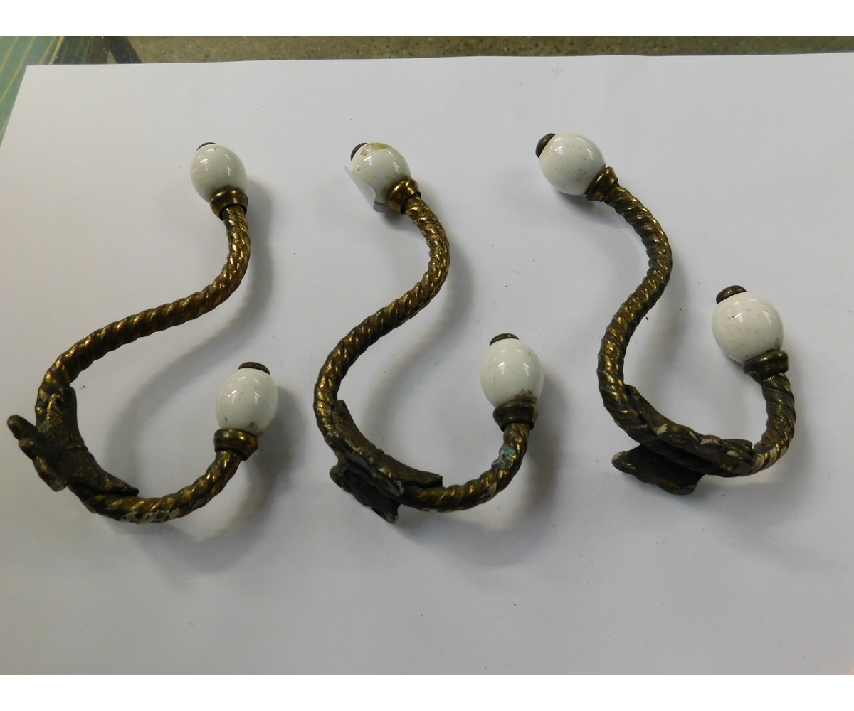 THREE VICTORIAN TWISTED BRASS AND PORCELAIN MOUNTED COAT HOOKS