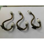 THREE VICTORIAN TWISTED BRASS AND PORCELAIN MOUNTED COAT HOOKS