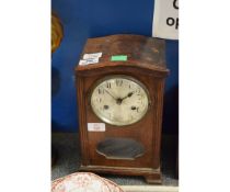MID-20TH CENTURY OAK CASED MANTEL CLOCK, THE ARCHED HOOD (DETACHED) WITH CANTED AND REEDED CORNERS