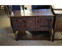 OAK FRAMED SMALL PROPORTIONED SIDEBOARD WITH TWO CUPBOARD DOORS WITH CARVED SCROLLING DESIGNS WITH