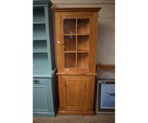 MODERN OAK FRAMED FLOOR STANDING CORNER CUPBOARD WITH SINGLE GLAZED DOOR OVER PANELLED DOOR WITH