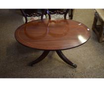 REPRODUCTION MAHOGANY OVAL COFFEE TABLE ON A TRIPOD BASE WITH REEDED LEGS AND BRASS PAW CASTERS