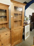 MODERN OAK FRAMED FLOOR STANDING CORNER CUPBOARD WITH SINGLE GLAZED DOOR OVER PANELLED DOOR WITH