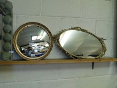 CIRCULAR CONVEX MIRROR TOGETHER WITH A METAL FRAMED OVAL MIRROR WITH URN TOP