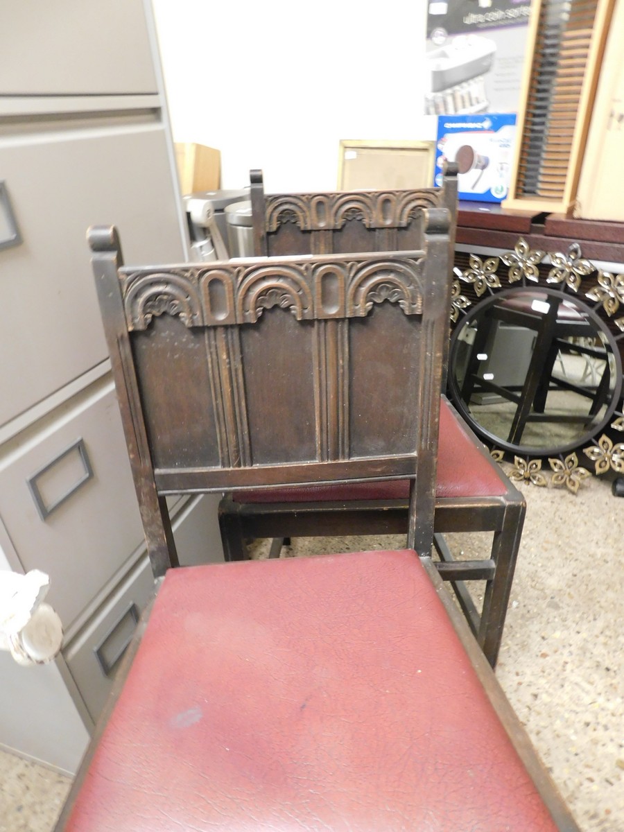 TWO MID-20TH CENTURY OAK GOTHIC EFFECT DINING CHAIRS WITH PANELLED BACK AND RED DROP IN SEATS