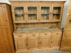 GOOD QUALITY WAXED PINE DRESSER, THE TOP FITTED WITH FOUR GLAZED DOORS, THE BASE WITH FOUR DRAWERS