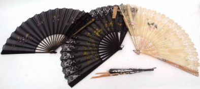 Group of four fans with wooden sticks and floral decoration on lace