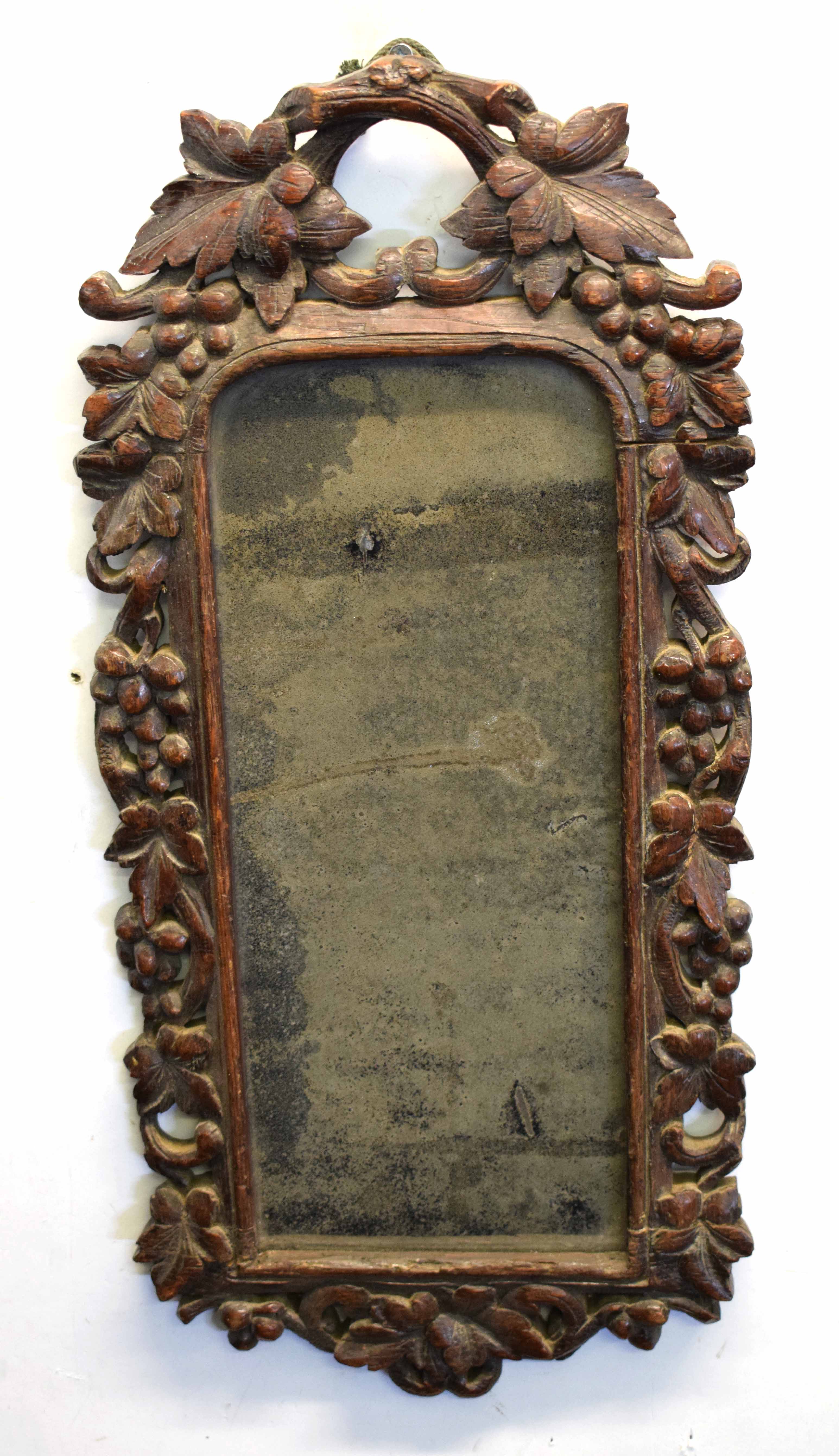 Unusual Black Forest or Bavarian oak wall mirror, the frame intricately carved with berries and