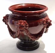 Large ruby coloured pottery jardiniere by Clement Massier, the pottery body modelled with lions