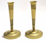 Pair of Eastern brass candlesticks on circular bases with conical columns with an etched design,