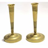 Pair of Eastern brass candlesticks on circular bases with conical columns with an etched design,