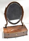 Early 19th century mahogany toilet mirror, oval mirror back and bowed support with drawer on ogee