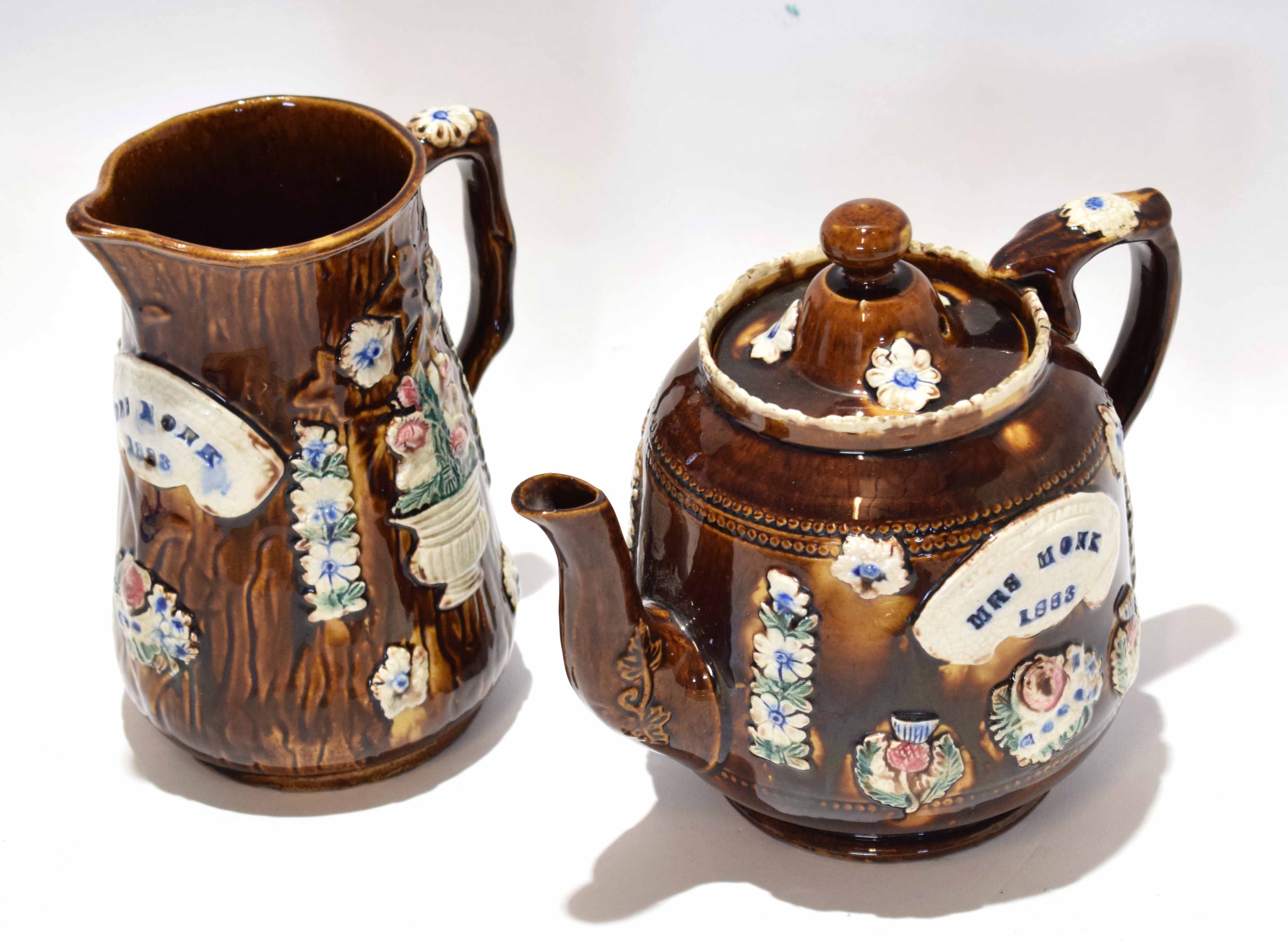 Barge ware type tea pot, the chocolate glaze with typical applied designs and the name Mrs Monk 1883