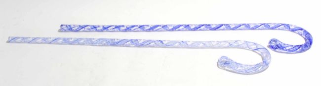 Two glass walking canes, one with a blue coloured swirled design, the other with similar decoration,