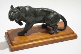Green spelter model of a stalking tiger on a mahogany stepped plinth, 26cm wide x 16cm tall