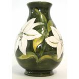 Moorcroft baluster vase decorated with white tube lined flowers on a green ground, Moorcroft stamp