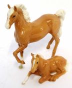 Two John Beswick horse figures, one of a prancing horse, the other a foal lying down, the horse 15cm