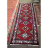 Good quality multi-coloured floor runner with red field and repeating diamond lozenge centre, 83cm