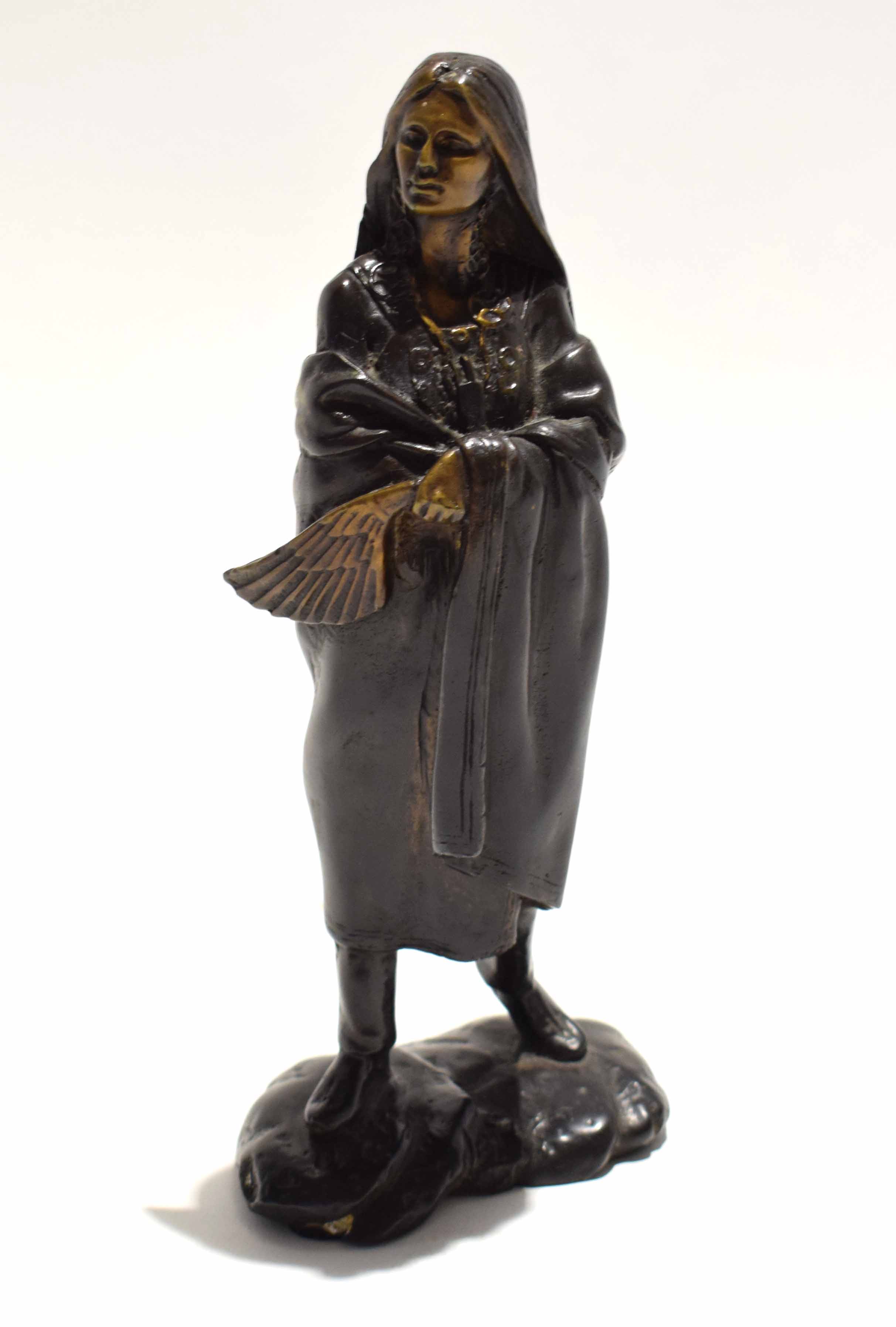 Bronze figure of a North American Plains Indian with draped blanket to shoulders, standing on a rock