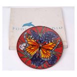 Poole Pottery charger with butterfly design on red ground, the base with factory mark, limited